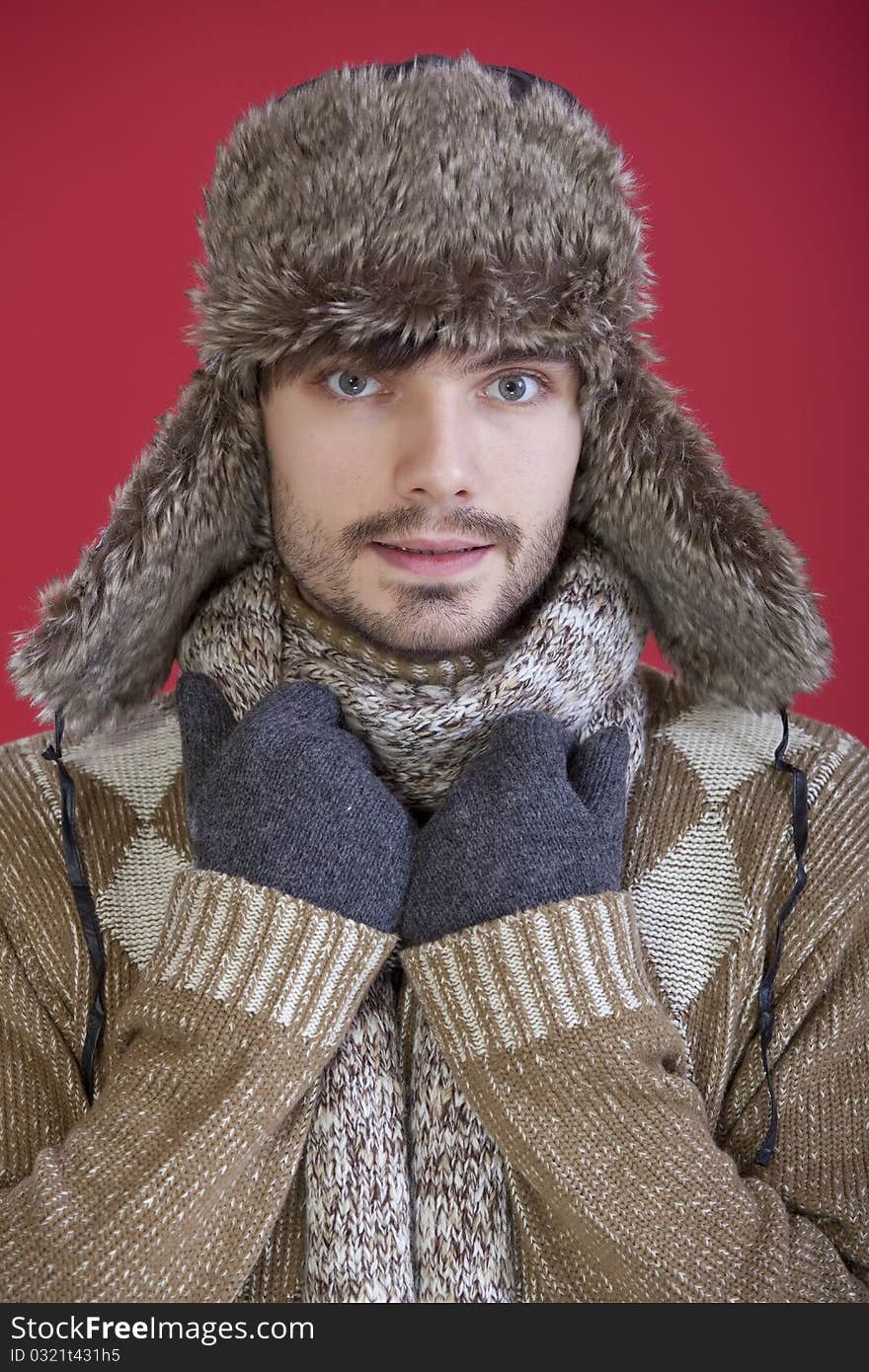 Young man in winter clothes over red background. Young man in winter clothes over red background