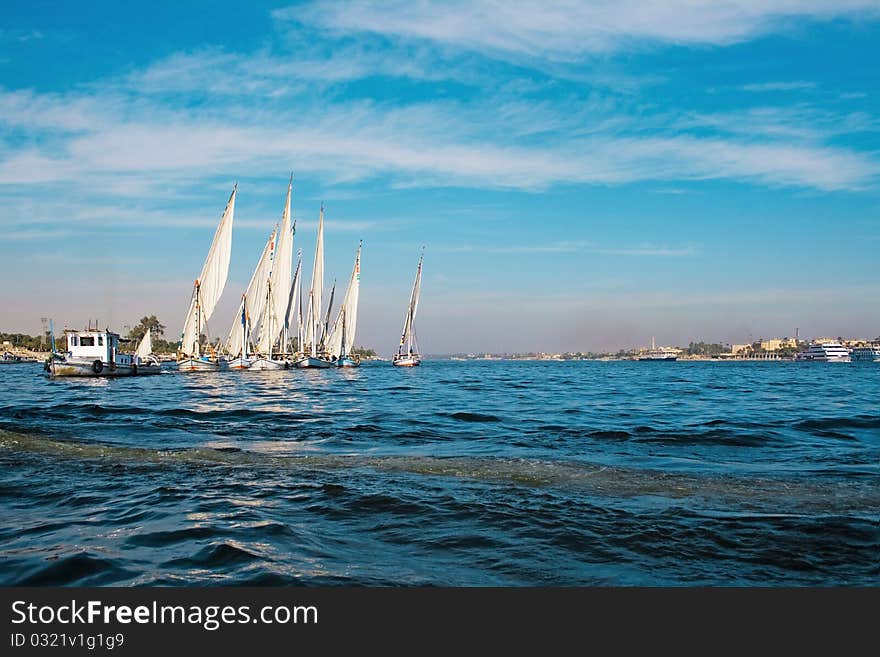 Sailboat sailing in the morning with blue cloudy sky. Sailboat sailing in the morning with blue cloudy sky