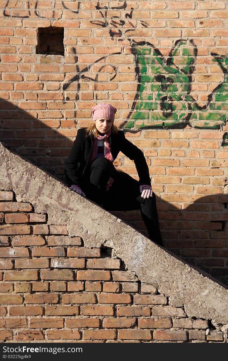 Beautiful young woman against the backdrop of a brick wall. Beautiful young woman against the backdrop of a brick wall