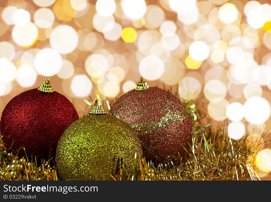 Red,yellow and gold Christmas baubles on background of defocused golden lights.Shallow DOF. Red,yellow and gold Christmas baubles on background of defocused golden lights.Shallow DOF