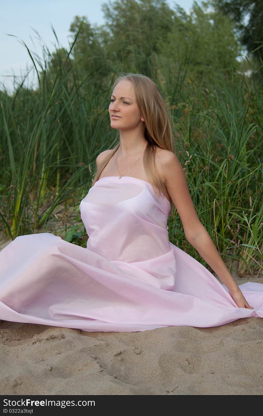 Beautiful pregnant with pink fabric fluttering in the wind. Beautiful pregnant with pink fabric fluttering in the wind