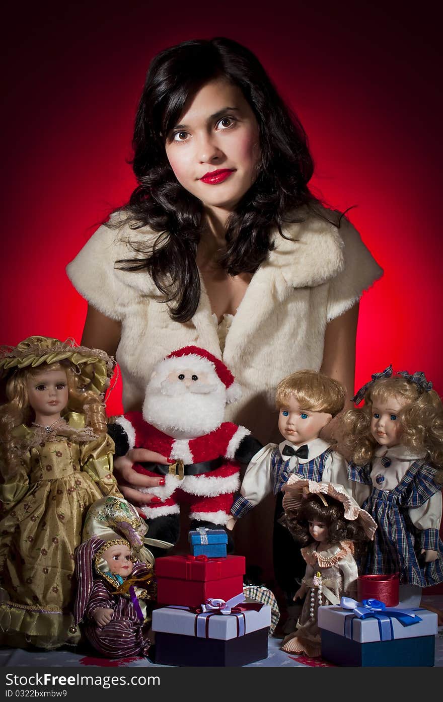 Young female with her dolls and santa claus receiving christmas gifts. Young female with her dolls and santa claus receiving christmas gifts