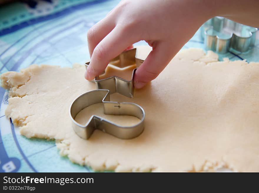 The young boy on a kitchen cut the cookies from the dough