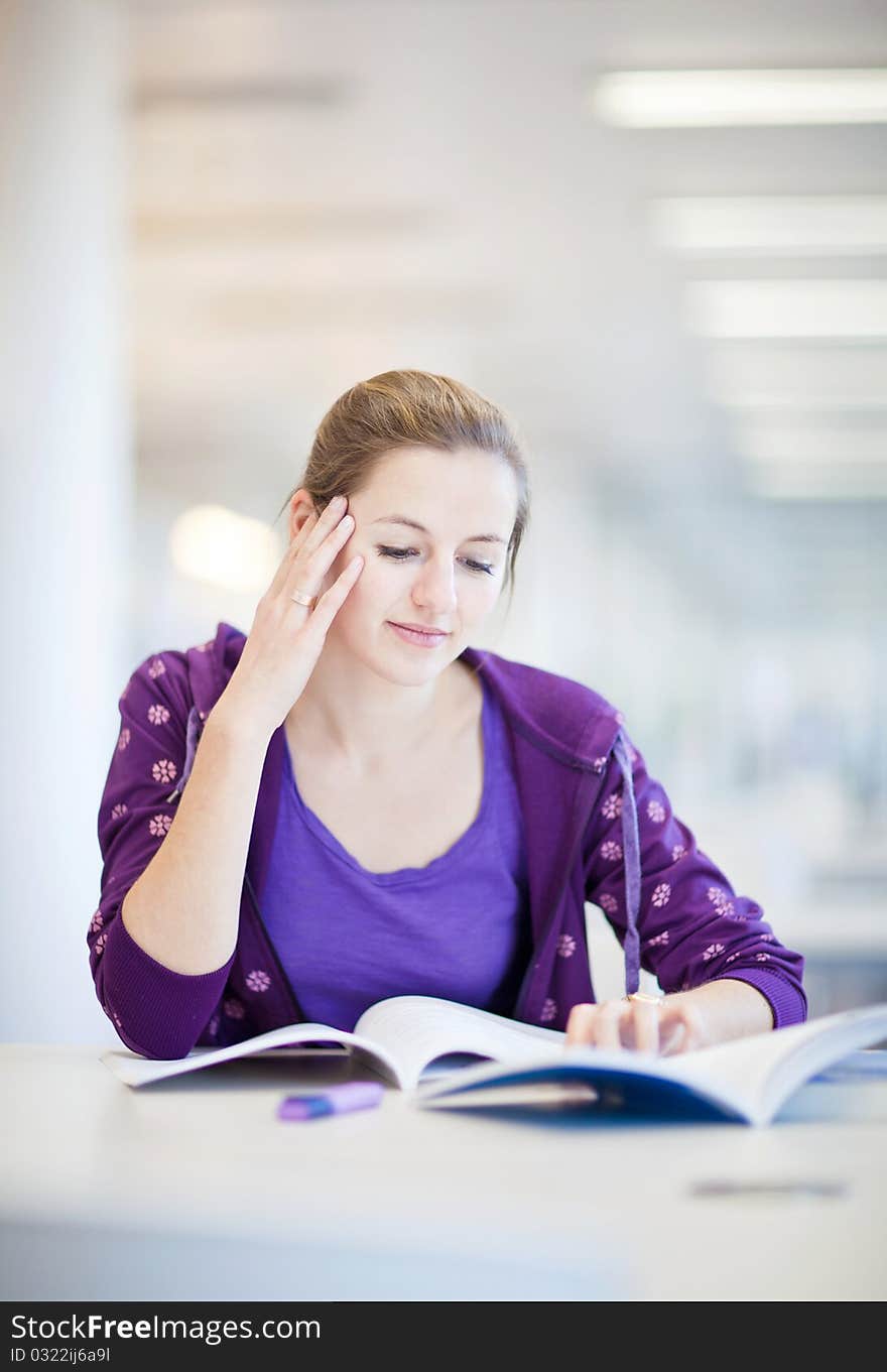 Pretty female college student in a library