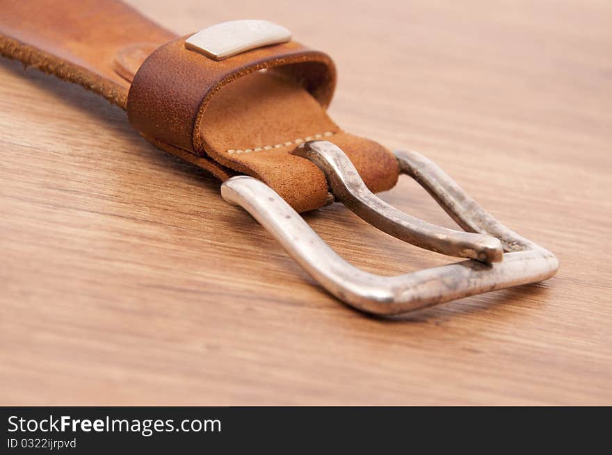 Belt of natural skin on a wooden