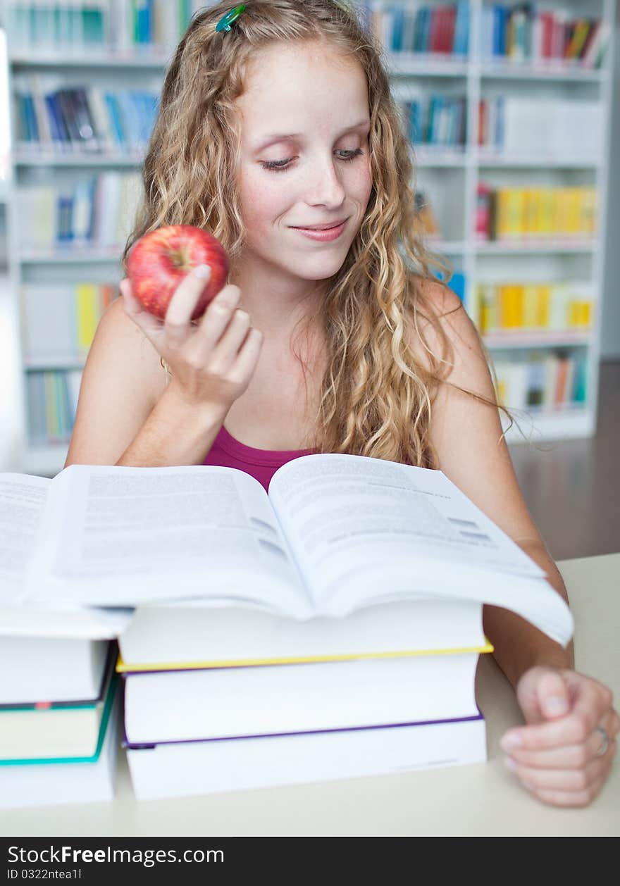 Pretty female college student in a library