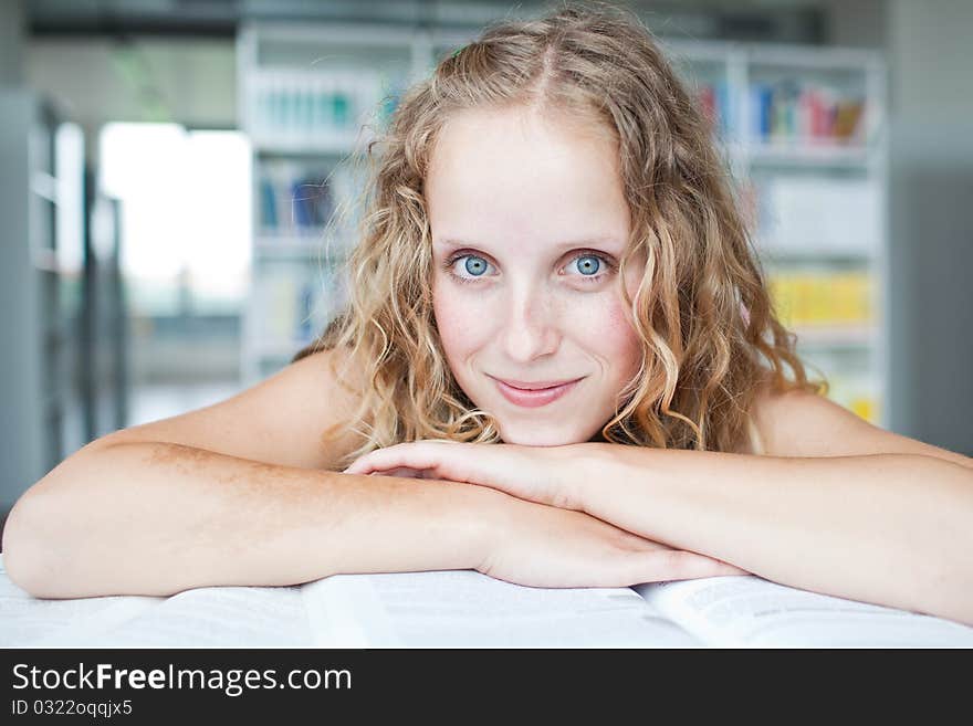 Pretty female college student in a library