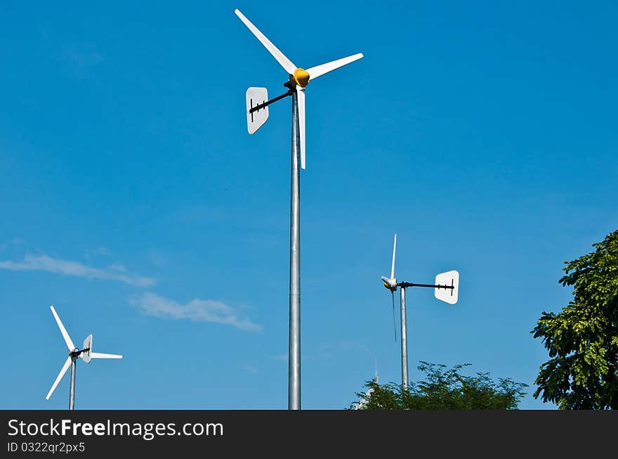 Windmills against a blue sky and clouds, alternative energy source. Windmills against a blue sky and clouds, alternative energy source