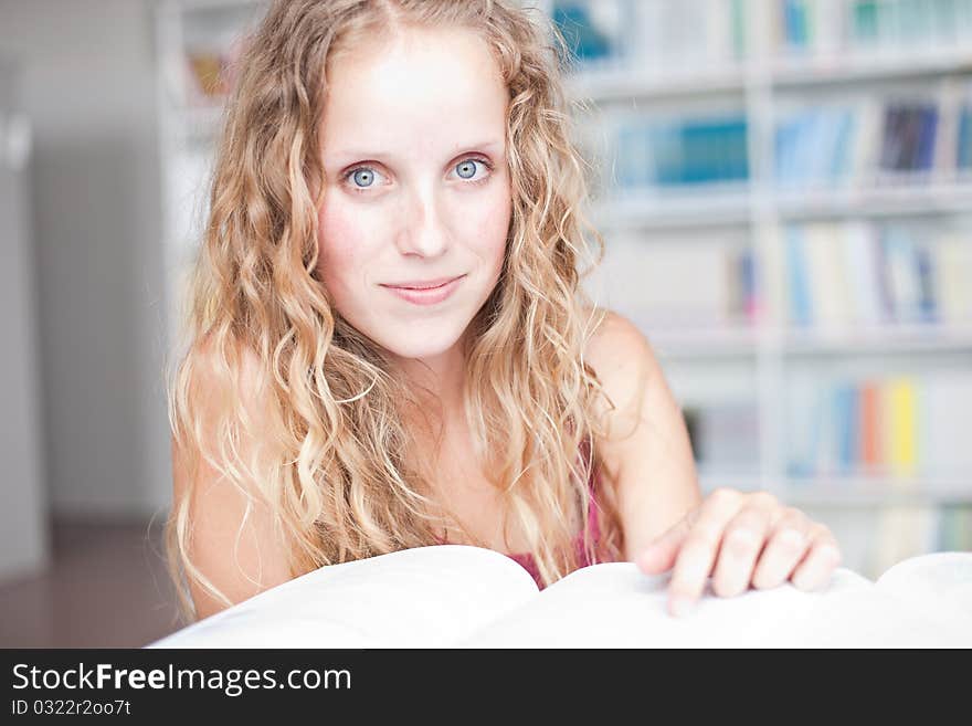 Pretty female college student in a library