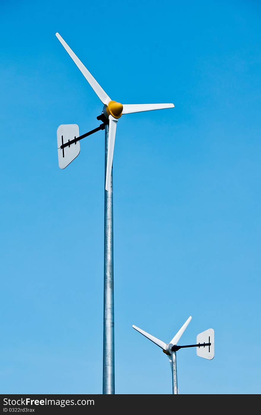 Windmills against a blue sky and clouds, alternative energy source. Windmills against a blue sky and clouds, alternative energy source