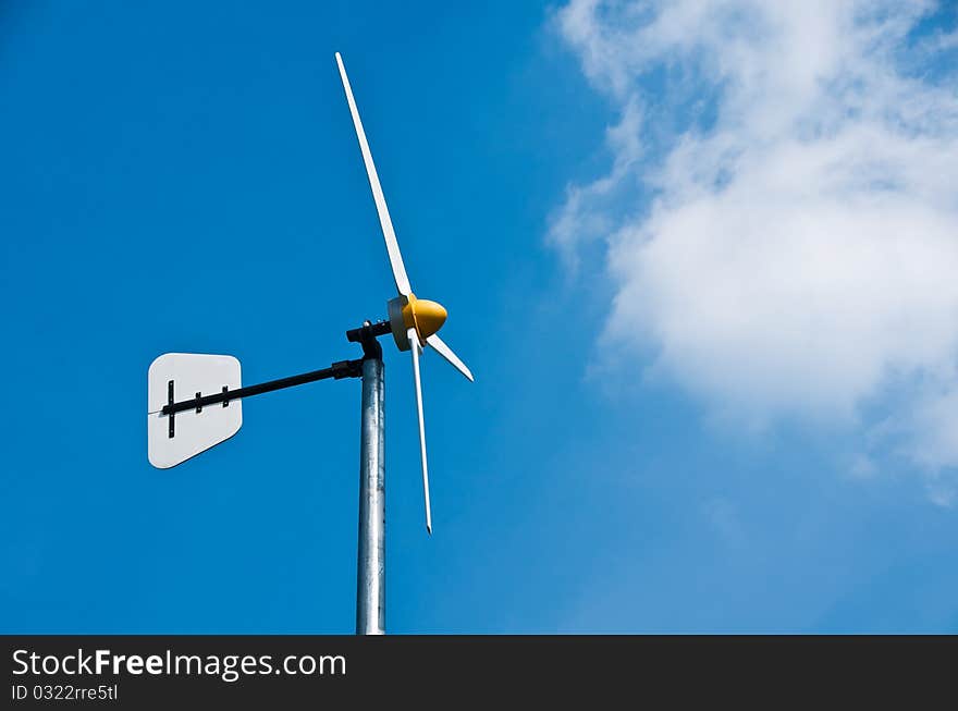 Windmills against a blue sky and clouds, alternative energy source. Windmills against a blue sky and clouds, alternative energy source