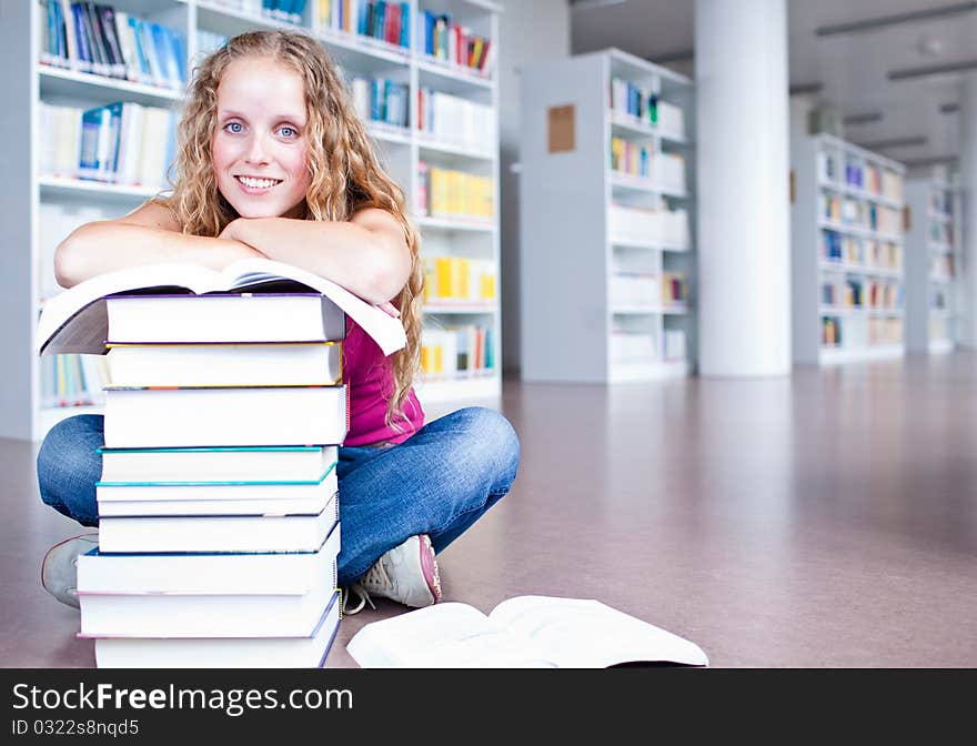 Pretty female college student in a library