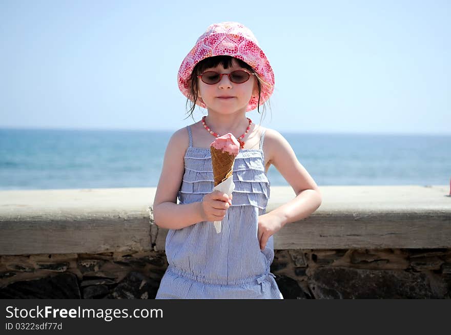 Small girl in glasess and sun hat on vacation with ice cream. Small girl in glasess and sun hat on vacation with ice cream