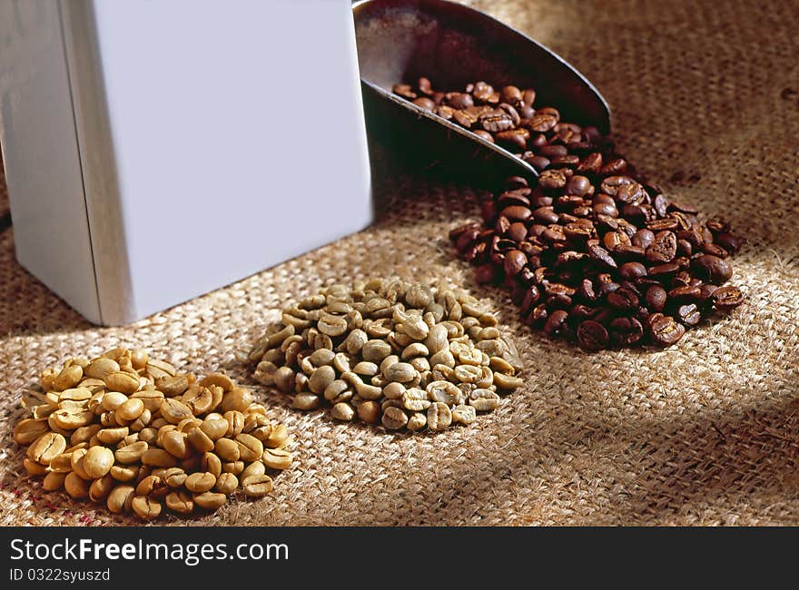 Roasted coffee beans on a spoon and table.