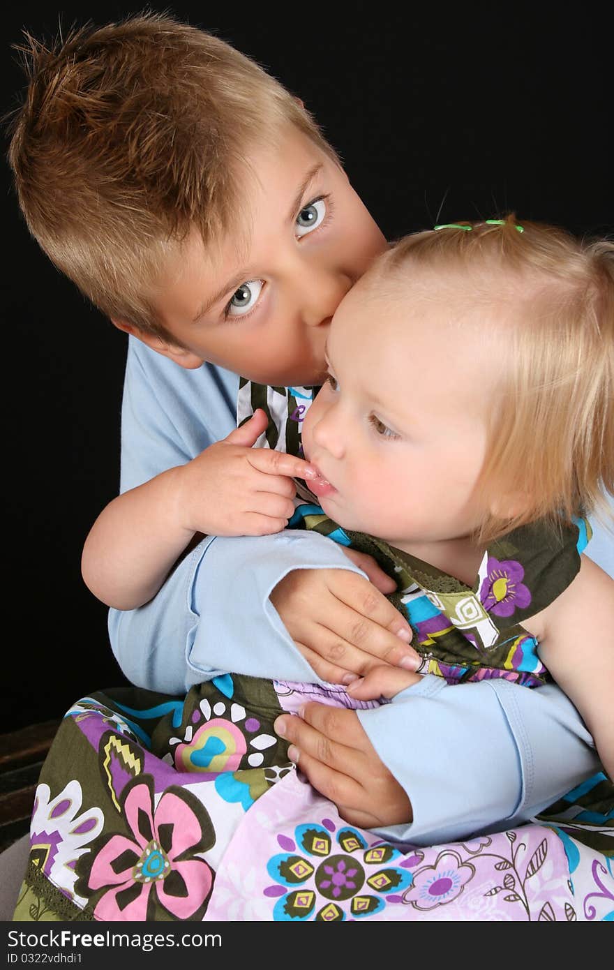 Cute brother holding his toddler sister in his arms. Cute brother holding his toddler sister in his arms