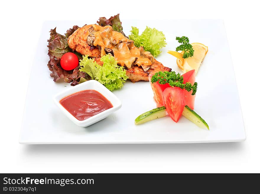 Meat dish steak with vegetables and herbs on a ceramic platter. Meat dish steak with vegetables and herbs on a ceramic platter