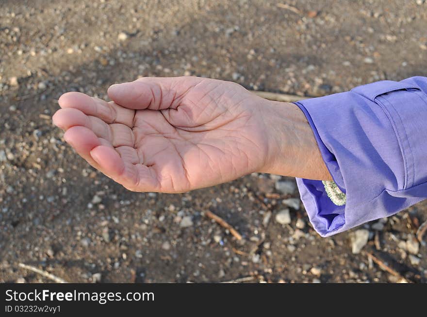 Outstretched hand of an elderly woman begging