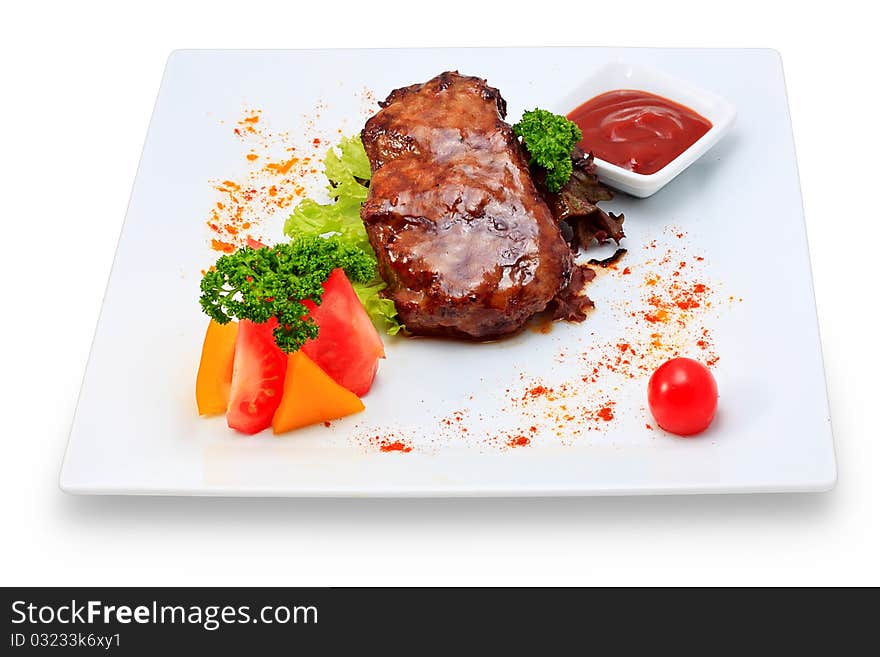 Meat dish steak with vegetables and herbs on a ceramic platter. Meat dish steak with vegetables and herbs on a ceramic platter