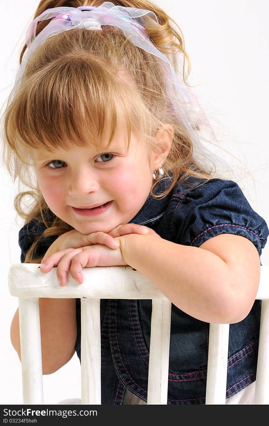 Pretty girl in blue dress sitting white chair