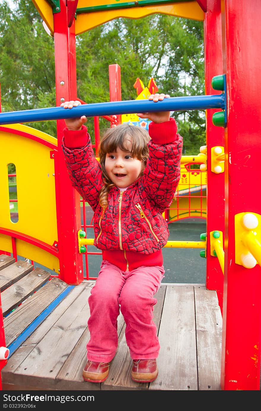 Little girl plays in playground in a park