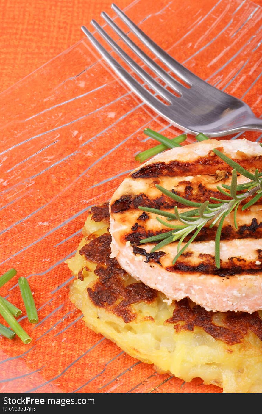 Roesti and grilled salmon with chives and rosemary served in a glass dish