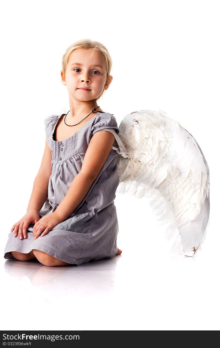 Beautiful girl with angel wings sitting isolated on white