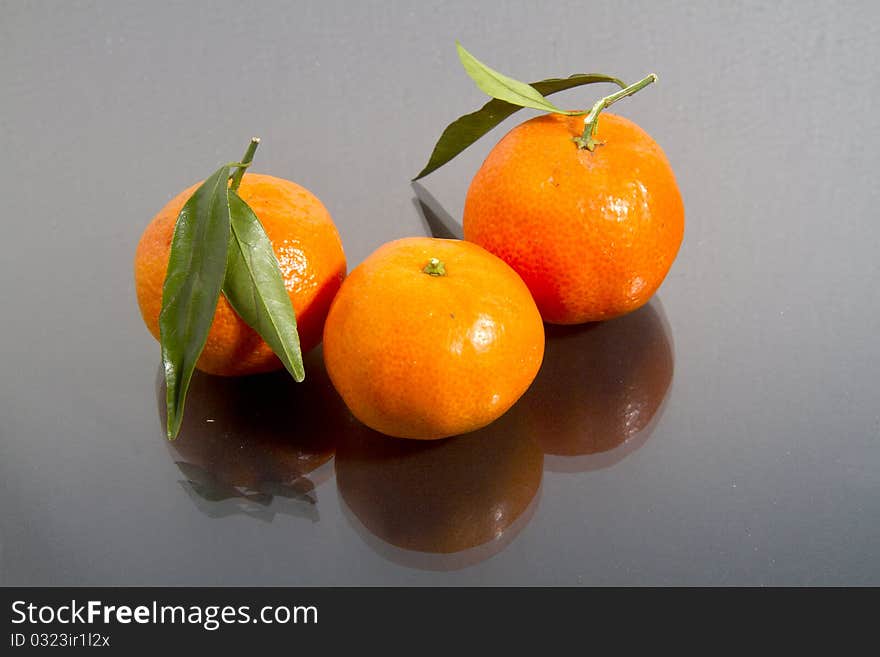 Mandarin oranges isolated on black gloss. Mandarin oranges isolated on black gloss