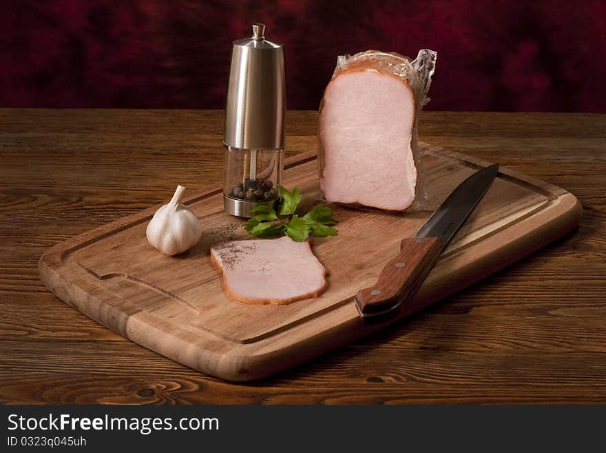 Composition with smoked vacuum packed ham on the table. Composition with smoked vacuum packed ham on the table