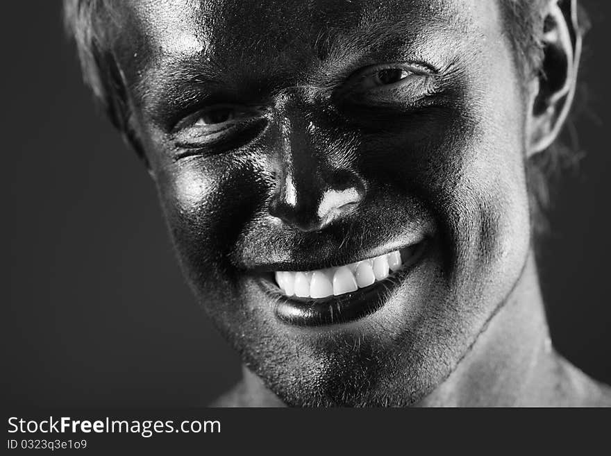 Portrait of expressive man painted with black color. Body painting project. Portrait of expressive man painted with black color. Body painting project.