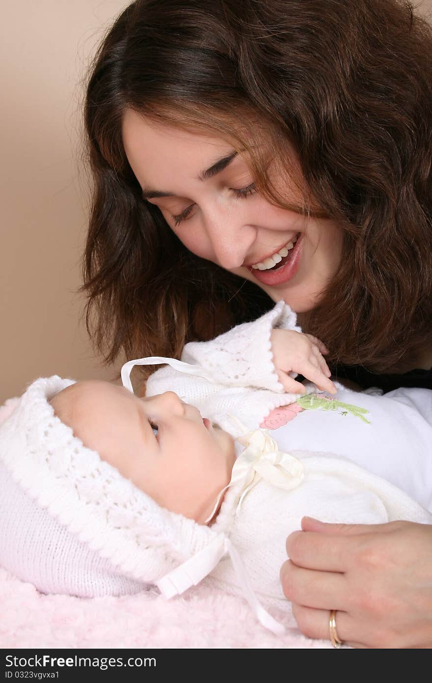 Beautiful brunette mother looking at her two month old baby girl. Beautiful brunette mother looking at her two month old baby girl