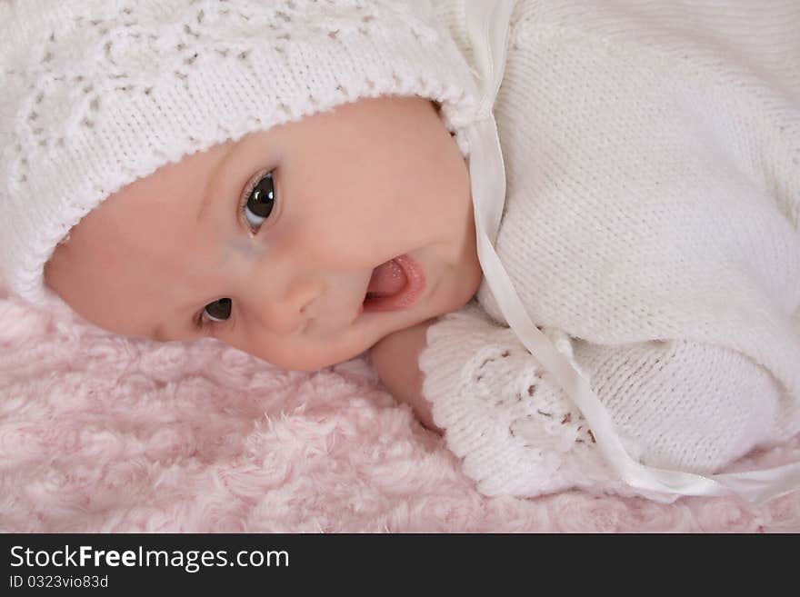 Beautiful two month old baby girl wearing a knitted outfit