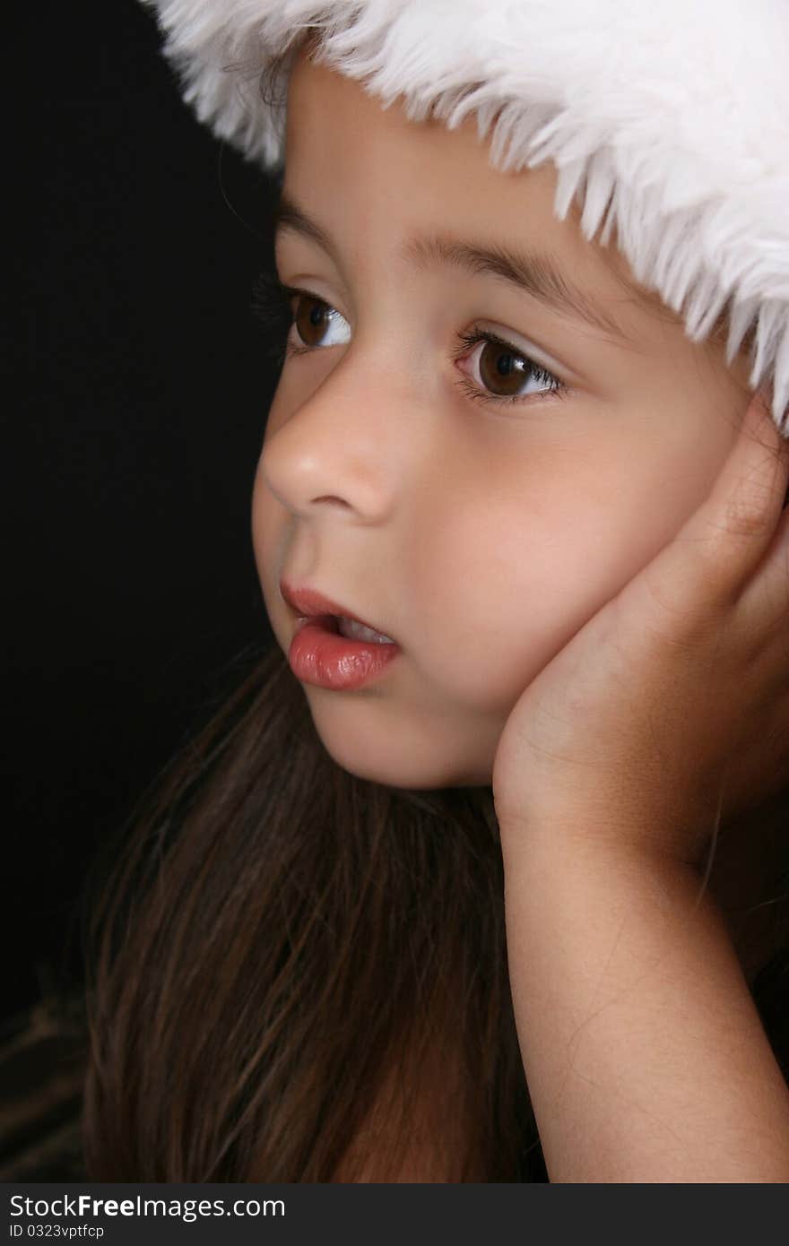 Cute little brunette girl wearing a christmas hat. Cute little brunette girl wearing a christmas hat