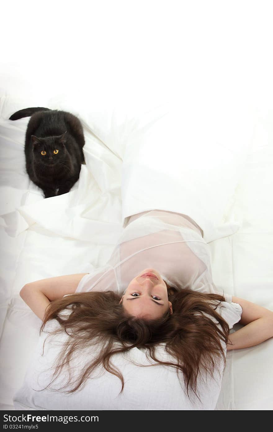 Woman in a bed with her black cat. Woman in a bed with her black cat