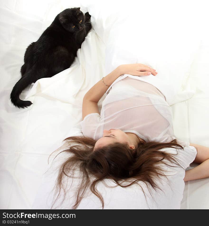 Woman in a bed with her black cat. Woman in a bed with her black cat