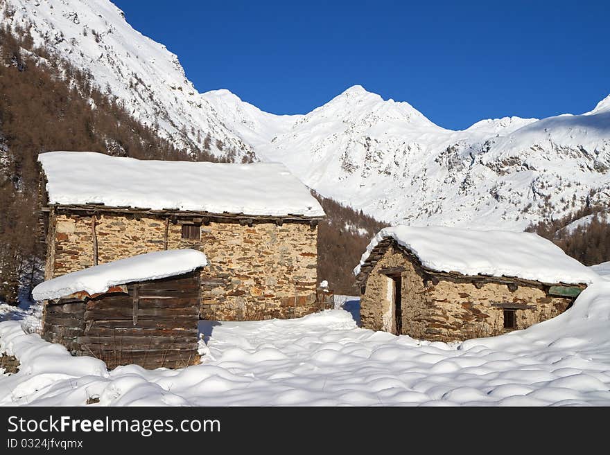 Cabins in a mountain valley in the North of Italy during winter. Valle delle Messi, Brixia province, Lombardy region, Italy. Cabins in a mountain valley in the North of Italy during winter. Valle delle Messi, Brixia province, Lombardy region, Italy