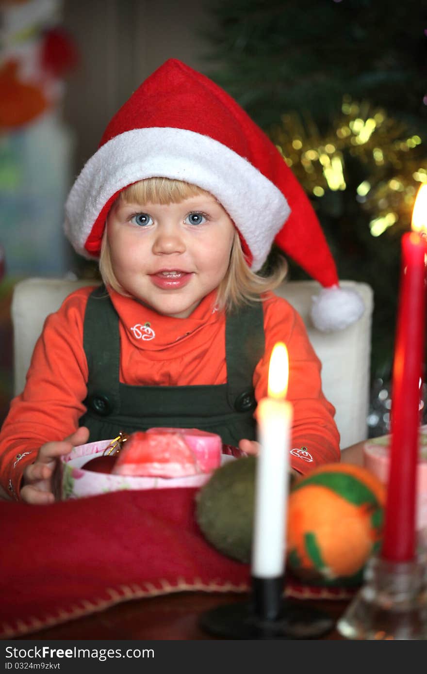 Small girl with gift christmas box and candle