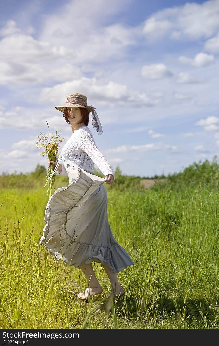 Barefooted young woman running in the field. Barefooted young woman running in the field