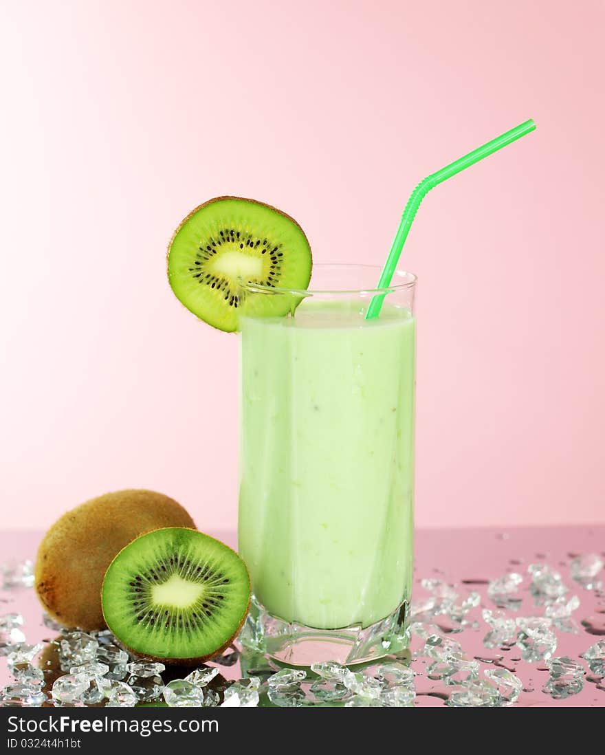 Kiwi juice in a glass on a pink background