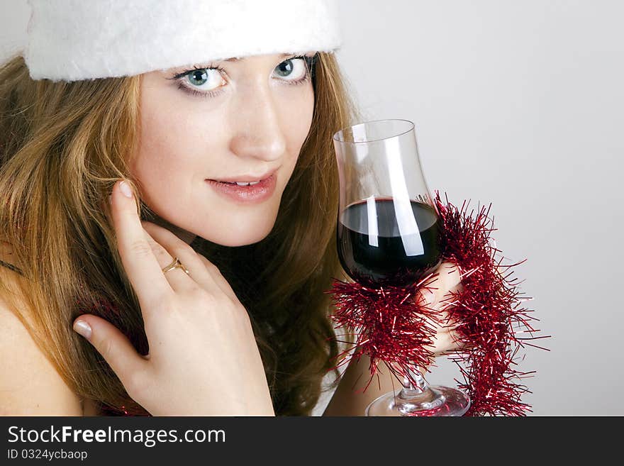 Girl in a Christmas hat drinking wine