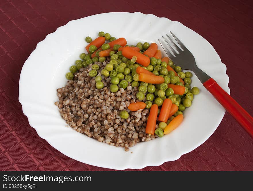 Buckwheatgroats with boiled green peas and baby carrot