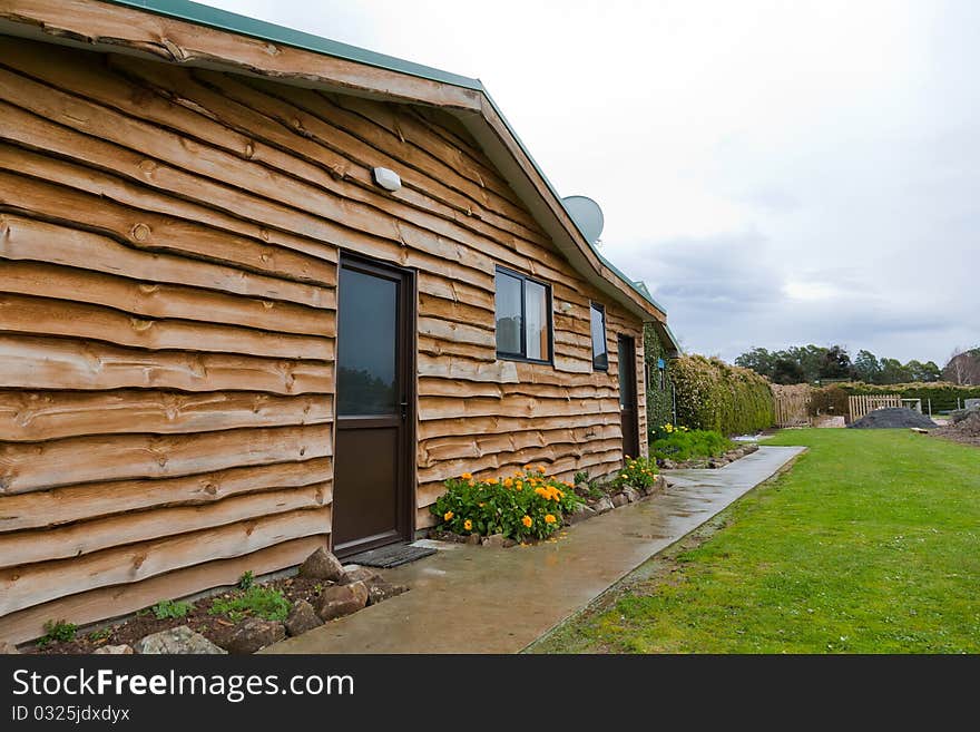 Wide angle view of a pretty log cabin in a rural area, Tasmania. Wide angle view of a pretty log cabin in a rural area, Tasmania.