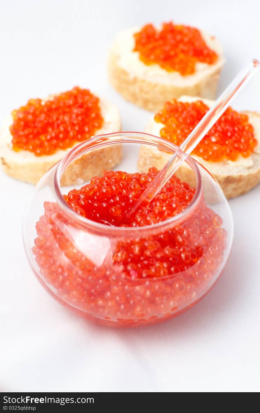 Jar with red caviar and sandwiches on whites tablecloth