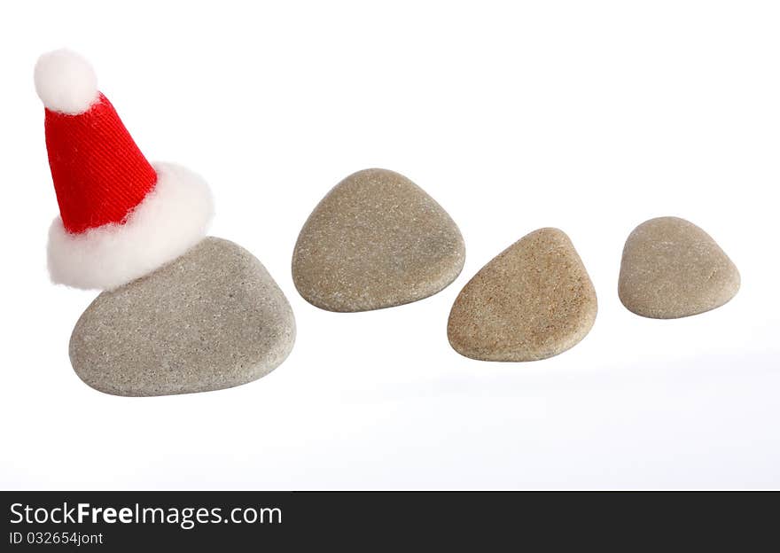 Four small stones with Santas cap isolated on white, copy space, you can write you numbers on stones