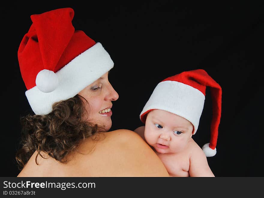 Beautiful mommy santa and her baby Santa boy on a black