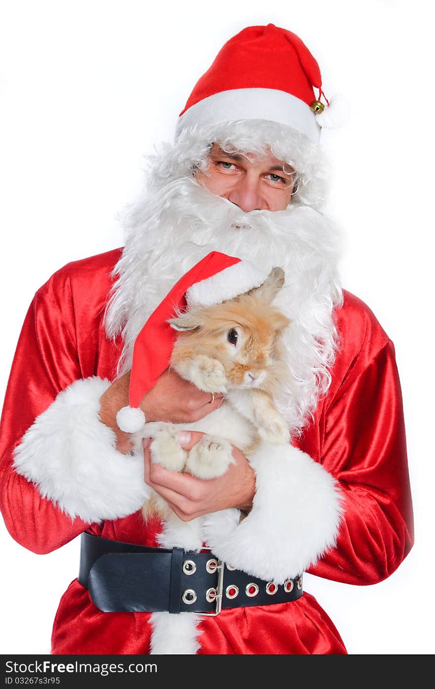 Photo of happy Santa Claus holding a cute rabbit in a santa hat.