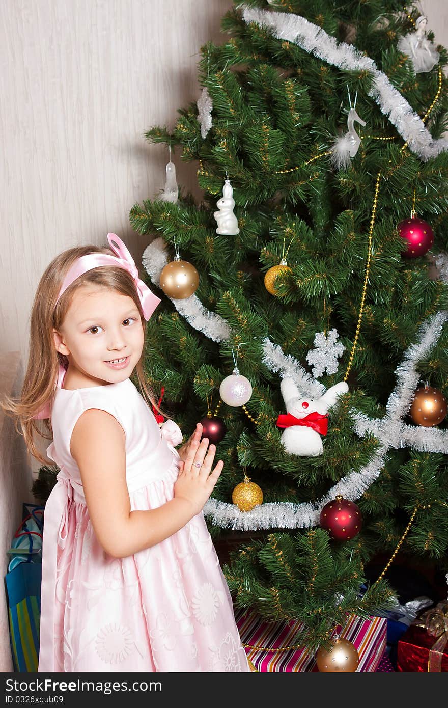 Lovely preschool girl decorating Christmas tree