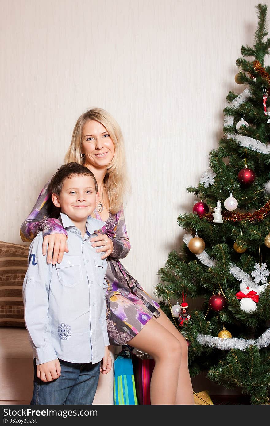 Happy mother with a son near a new-year tree. Happy mother with a son near a new-year tree