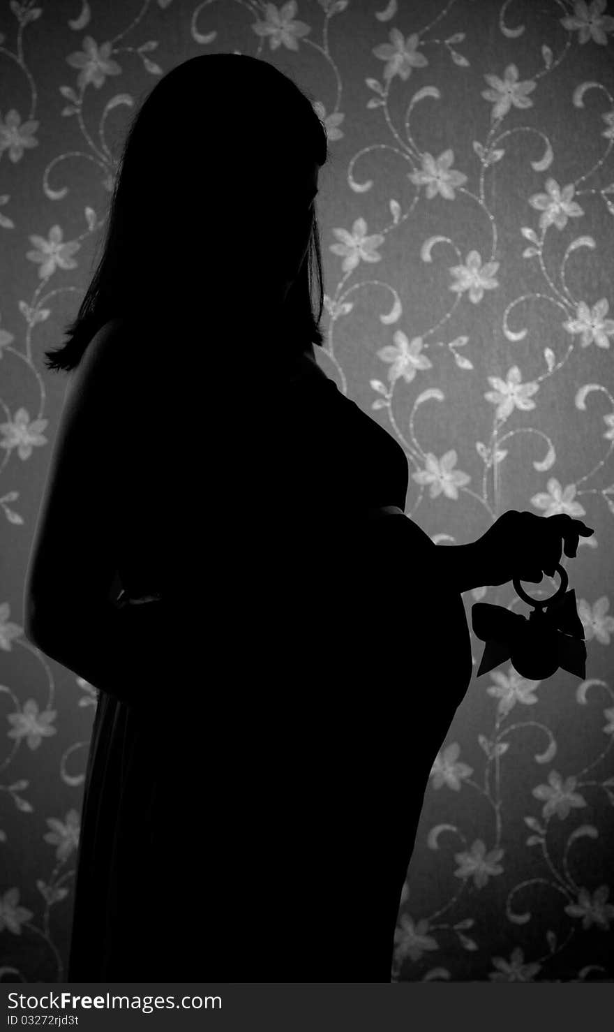 A silhouette of a pregnant woman at studio. A silhouette of a pregnant woman at studio