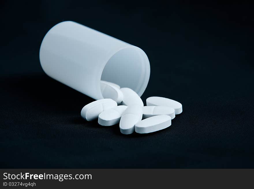 White tablets in a box on a black background