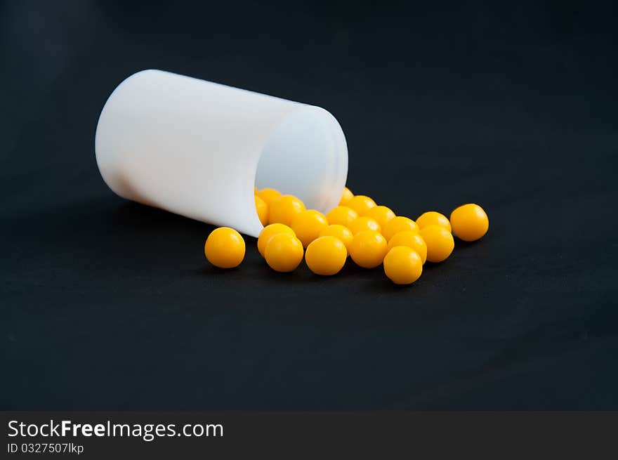 Yellow pills in a box on a black background. Yellow pills in a box on a black background